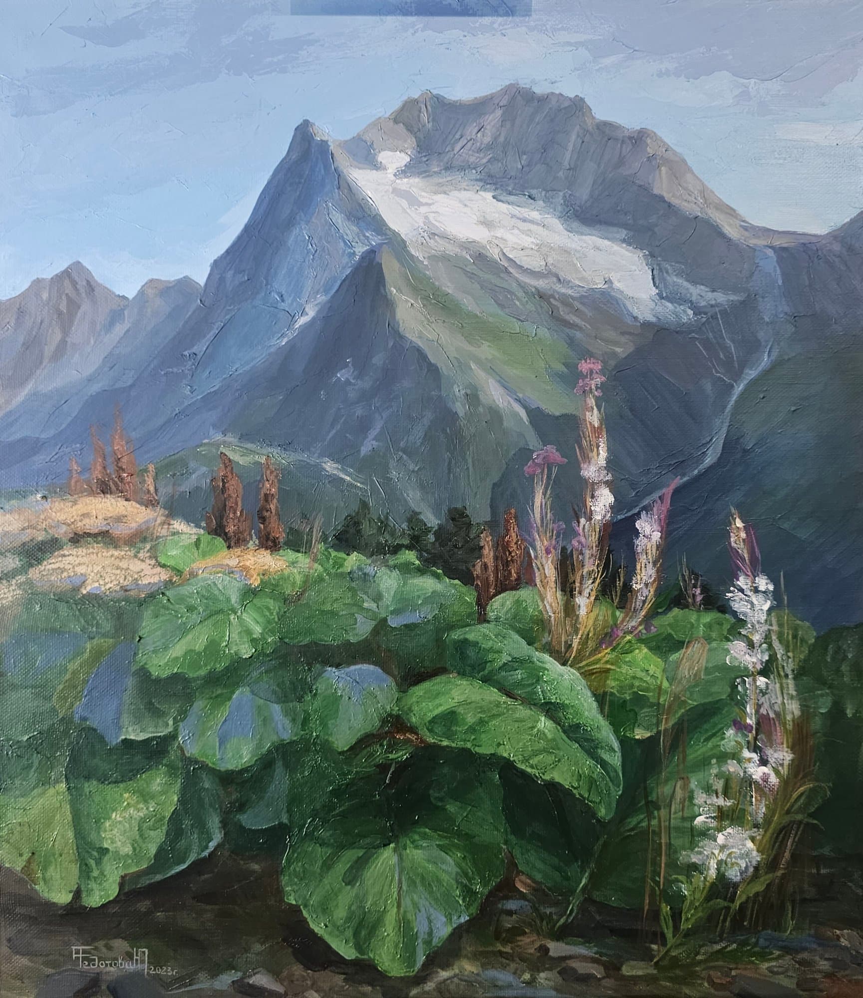 Mountain peak with a glacier, large green leaves and flowers in the foreground